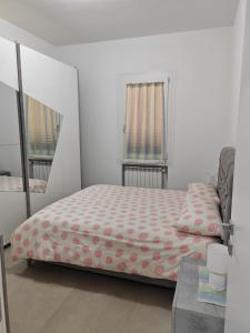 Dormitorio pequeño con cama y espejo en Appartamento Dolce Casa, en Imola