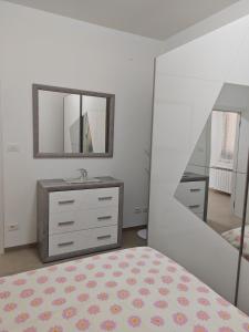 1 dormitorio con tocador y espejo en Appartamento Dolce Casa, en Imola