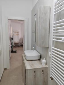 Baño blanco con lavabo y espejo en Appartamento Dolce Casa, en Imola