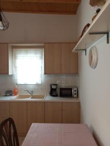 a kitchen with a sink and a microwave at Lefakis cottage in Órmos