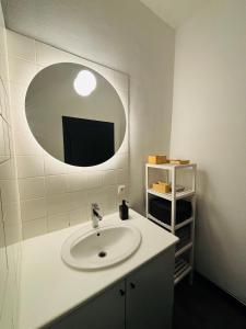 La salle de bains est pourvue d'un lavabo et d'un miroir. dans l'établissement Appartement Cosy Liège Station, à Liège