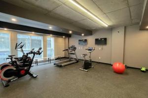 einen Fitnessraum mit Laufbändern und Heimtrainern in einem Zimmer in der Unterkunft Condo chic, centre-ville piscine, terrasse, gym in Québec