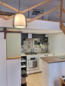 a kitchen with white appliances and a ceiling at Studio le petit nid douillet - Centre ville in Les Andelys