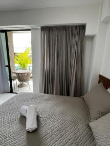 ein Schlafzimmer mit einem Bett und einem Handtuch darauf in der Unterkunft Makia Beach Experience Muro Alto Porto de Galinhas in Porto De Galinhas