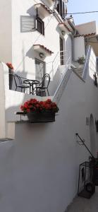 a white building with a table and chairs and flowers at Old Town Baska in Baška