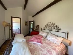 a bedroom with a bed with a red pillow on it at Villa Lavanda 10 Pax By VILLASRETREATS in Beverino +72 photos