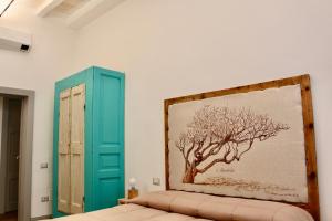 a bedroom with a painting of a tree on the wall at Suites Cavallotti - Il Mandorlo in Orvieto