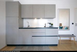 una cocina con armarios blancos y fregadero en Val De Laco studio apartments en Rovinj