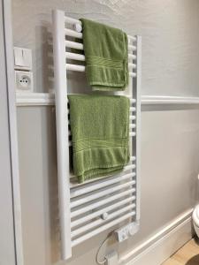 a towel rack in a bathroom with green towels at Studio le petit nid douillet - Centre ville in Les Andelys