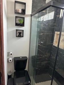 a bathroom with a toilet and a glass shower at Flat Jk 01 térreo in Juazeiro do Norte