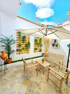a patio with two benches and an umbrella at Apartamentos de la Huerta in Alicante