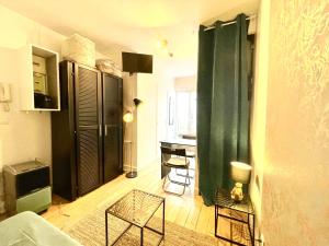 uma sala de estar com uma cortina verde e uma secretária em Appartement au calme em Saint-Ouen