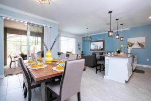 uma sala de jantar e sala de estar com mesa e cadeiras em Gorgeous 4Bd Close to Disney with Pool at Storey Lake 4403 em Kissimmee