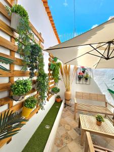 a patio with a bench and plants on a wall at Apartamentos de la Huerta in Alicante