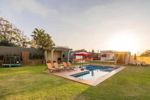 a yard with a swimming pool with chairs and a house at New Loft with Sky Bar and Pools in Oaxtepec