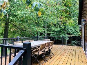 a wooden deck with a table and chairs on it at Sojourner's Lodge & Log Cabin Suites in Dundee