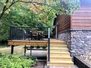 a wooden deck with a table and chairs on it at Sojourner's Lodge & Log Cabin Suites in Dundee