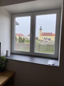 two windows in a room with a view of a building at Rodinný dům Radoška in Divišov