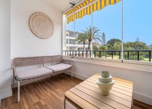 - un salon avec un canapé, une table et une fenêtre dans l'établissement Elegant Studio with Balcony, Pool & Parking, à Marbella