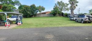 a yard with cars parked in front of a house at Nationwide Motel in Gympie