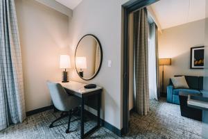 a hotel room with a desk and a mirror at Embassy Suites By Hilton Gatlinburg Resort in Gatlinburg