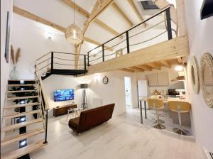 a loft apartment with a staircase and a living room at Magnifique grange rénovée au coeur de la Champagne in Les Mesneux