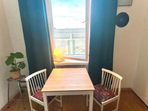 a table and chairs in a room with a window at Cozy nest, Kamppi in Helsinki +1 photo