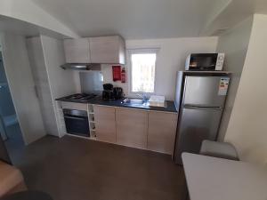 a small kitchen with a refrigerator and a sink at litteau 213 in Litteau