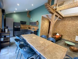 une cuisine avec une grande table et des chaises bleues dans l'établissement Grange rénovée, 6 minutes du Lac d'Annecy vue sur le Mont-Blanc, à Giez