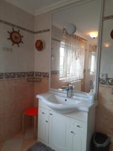 La salle de bains est pourvue d'un lavabo et d'un miroir. dans l'établissement Noclegi Sylana, à Kobyłka