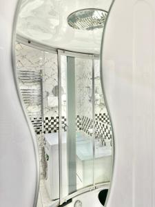 a mirror in a bathroom with a white room at Full Comfort Apartment at Chavchavadze in Tbilisi City