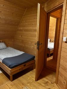 Habitación con cama y puerta abierta en Domek z bali Tryszczyn nad Brdą, en Tryszczyn