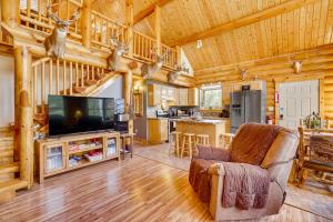 una sala de estar con TV en una cabaña de madera en Merrillan Cabin with Fire Pit Less Than 1 Mi to Lake Arbutus, en Merrillan