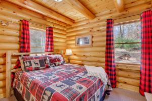 1 dormitorio con 1 cama en una cabaña de madera en Merrillan Cabin with Fire Pit Less Than 1 Mi to Lake Arbutus, en Merrillan