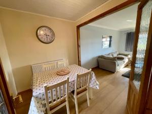 a dining room with a table and a clock on the wall at Fort William - Highland holiday home in Fort William