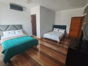 1 dormitorio con 1 cama y 1 cama y 1 cama pequeña sidx sidx sidx en HOTEL EL TREBOL, en Yurimaguas