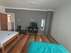 1 dormitorio con 1 cama y suelo de madera en HOTEL EL TREBOL, en Yurimaguas