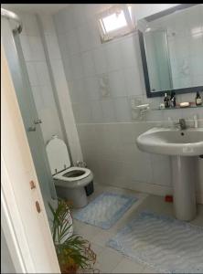 a small bathroom with a toilet and a sink at Island House in Adalar