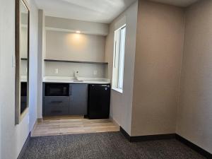 uma cozinha vazia com um lavatório e uma janela em Vittoria Hotel & Suites em Cataratas do Niágara