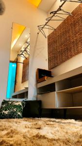 a living room with a couch and a mirror at Ninho de Aço - Casa Container! in Uberlândia