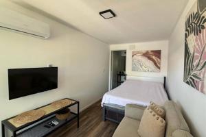a small bedroom with a bed and a couch at Euphorbia in Cuchilla Alta