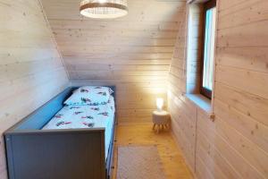 Cette petite chambre comprend un lit dans une cabane en bois. dans l'établissement Panorama Sucha Góra ,Leśny domek, à Skawica