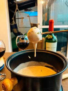 um pote de sopa com uma colher com vinho em Casa Contêiner Alvenaria Elegant em Uberlândia