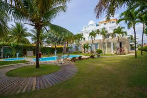 a resort with a swimming pool and a building at Apartamento beira-mar em Carneiros in Tamandaré +17 photos