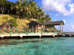 una pequeña casa en un muelle sobre el agua en Native Lodge Brisas del Sur, en Providencia