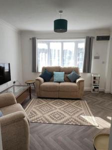 a living room with a couch and a tv at Annie's Hideaway in Chapel Saint Leonards