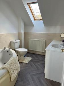 a bathroom with a toilet and a tub and a sink at Annie's Hideaway in Chapel Saint Leonards