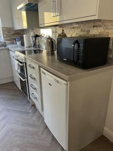 a kitchen with a counter with a microwave and a stove at Annie's Hideaway in Chapel Saint Leonards
