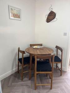 a wooden table and chairs in a room at Annie's Hideaway in Chapel Saint Leonards