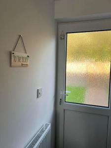 a door in a room with a sign on the wall at Annie's Hideaway in Chapel Saint Leonards